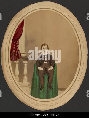 (Porträt eines Jungen). Robert Neff Keeley, Fotograf (Amerikaner, 1828–1896) 1850er Jahre handkoloriertes Studioporträt eines jungen Jungen, der auf einem Stuhl sitzt, der mit grünem Tuch bedeckt ist. (Recto, Halterung) untere mittlere Halterung, Buchdruck in goldfarbener Tinte: „Phot. Von R. N. Keeley, 5th & Coates St. Philada'; (Verso, Mount) oben in der Mitte, in Bleistift: 'GE96/2754'; '7 7/8 x 6 1/8' / montiert'; '275' [durchgestrichen]; Mitte, in Bleistift: 'Cooper / 5771'; unten rechts, in Bleistift: '92315 / x 82'; Stockfoto