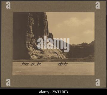 Canyon de Chelley - Navajo. Edward S. Curtis, Fotograf (Amerikaner, 1868–1952) 1904 Sieben Reiter und Hund aus der Ferne mit Klippen hinter ihnen Inschrift: Negativ signiert: 'CURTIS'. Sekundäre Inschrift: Verso-Montierung in Bleistift von einer unbekannten Hand: (Mitte)'86336'. Stockfoto