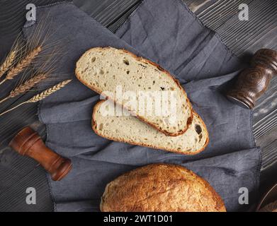 Geschnittener Brotlaib auf Holzbrett. In Scheiben geschnittenes Sauerteigbrot Stockfoto