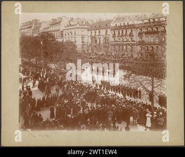 Parade von Zar Nikolaus II. Und Präsident Felix Faure durch Paris. Unbekannt, Fotograf 6. Oktober 1896 Menschenmassen versammelten sich auf der Straße und auf Balkonen und Dächern benachbarter Gebäude, um eine Parade zu beobachten. Die Parade besteht aus zwei Pferdekutschen, die von einem Soldaten zu Pferd geführt werden. Soldaten stehen auf beiden Seiten der Straße zu sehen, einander gegenüber. (Recto, Mount) unten links, Bleistift: 'Zar Nicolas'; (Verso, Mount) oben in der Mitte, schwarze Tinte: "Le Tzar Nicolas II, la tzarine [sic] et le President Felix Faure précédés du pigneur Montjarret - 6. Oktober 1896."; obere Mitte, Stockfoto
