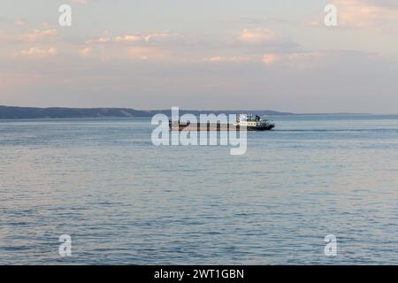 Tetyushi, Tatarstan - 2. Mai 2022: Ein großes schwarzes Frachtschiff fährt entlang des Flusses Kama. Stockfoto