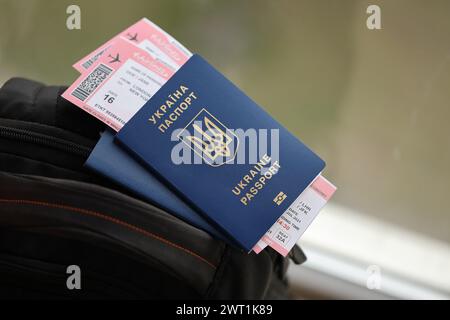 Zwei ukrainische biometrische Pässe mit Flugtickets auf schwarzem touristischem Rucksack Nahaufnahme Stockfoto