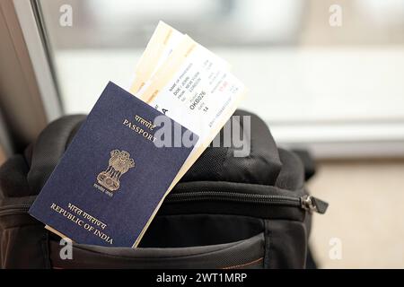 Blauer indischer Pass mit Flugtickets auf touristischem Rucksack aus nächster Nähe. Tourismus und Reisekonzept Stockfoto