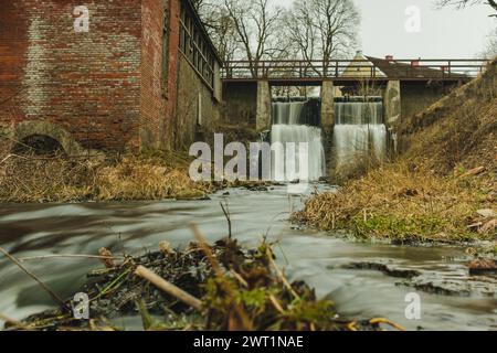 Tauchen Sie ein in die Symphonie der Natur am Aleksupite Wasserfall, wo das rhythmische Rauschen des Wassers durch Kuldiga, Latvija, hallt Stockfoto