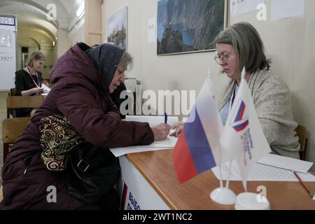 St. Petersburg, Russland. März 2024. Ein Wähler meldet sich zur Wahl an einem Wahllokal in St. Petersburg, Russland, 15. März 2024. Die achte russische Präsidentschaftswahl beginnt am Freitag und wird bis Sonntag fortgesetzt. Vier Kandidaten sind für die Wahl registriert: Der amtierende russische Präsident Wladimir Putin, der Vorsitzende der Liberaldemokratischen Partei Leonid Slutsky, Wladislav Davankow von der russischen Neuen Volkspartei und Nikolai Kharitonow, der Kandidat der Kommunistischen Partei Russlands. Quelle: Eine Xiaomeng/Xinhua/Alamy Live News Stockfoto