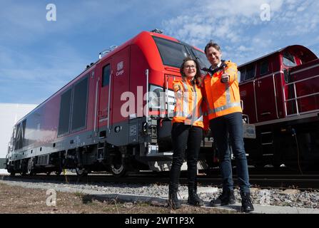 15. März 2024, Sachsen-Anhalt, Halle (Saale): Sigrid Nikutta, CEO von DB Cargo, und Michael Peter, Geschäftsführer von Siemens Mobility, stehen im Güterbahnhof vor einer neuen Hybridlokomotive. Künftig wird die neue Generation von Triebwerken rein elektrisch auf elektrifizierten Gleisabschnitten betrieben, während auf Abschnitten ohne Freileitungen ohne Wechsel der Lokomotiven auf konventionellen Antrieb umgeschaltet werden kann. Die Hybridlokomotiven, die Vectron Dual Mode Light genannt werden, werden vom Bahnanbieter Siemens Mobility hergestellt. Wenn die Lokomotive mit grünem Strom betrieben wird Stockfoto