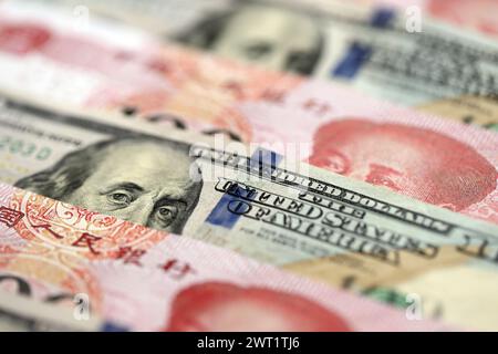 Viele Geldscheine der Volksrepublik China und der Vereinigten Staaten. PRC Yuan- und USD-Dollar-Banknoten aus nächster Nähe Stockfoto