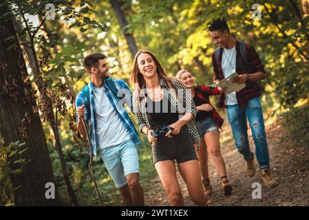 Eine Gruppe von vier Freunden Spaß wandern durch Wald zusammen. Stockfoto