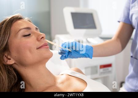 Frau in einem Schönheitssalon entfernt Gesichtsbehaarung mit Laser-Epilierung. Stockfoto