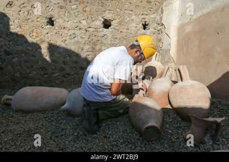 Restaurator bei der Arbeit an Amphoren im Schola Armaturarum, der ersten Ausgrabung von Pompeji in einem Gebiet, das nie untersucht wurde, nach mehr als 2 Stockfoto