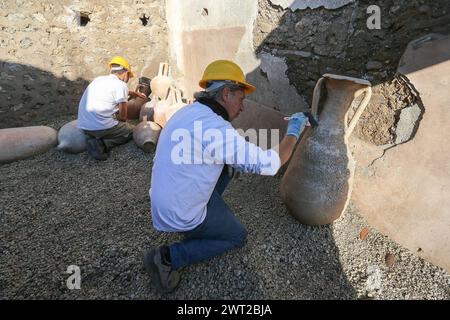 Restauratoren arbeiten an Amphoren im Schola Armaturarum, der ersten Ausgrabung von Pompeji in einem Gebiet, das nie untersucht wurde, nach mehr als Stockfoto