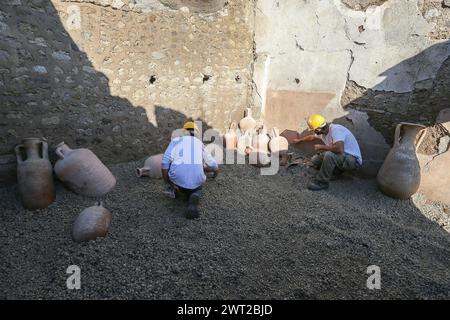 Restauratoren arbeiten an Amphoren im Schola Armaturarum, der ersten Ausgrabung von Pompeji in einem Gebiet, das nie untersucht wurde, nach mehr als Stockfoto