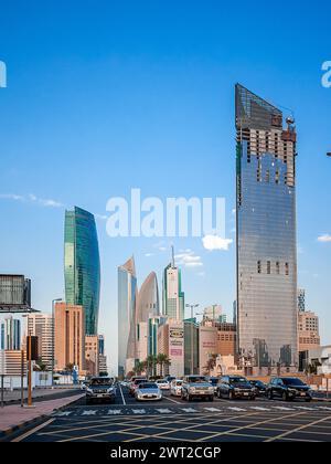 Eine Straße in Kuwait City mit Autos, die an den Ampeln und Wolkenkratzern im Hintergrund stehen Stockfoto