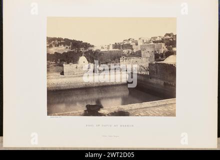 Pool von David in Hebron. John Cramb, Fotograf (Schottisch, aktiv 1850er - 1860er Jahre) 1860 Blick auf King David's Pool, auch King's Pool genannt, in Hebron, umgeben von den Backsteinmauern und Gebäuden der Stadt. Vieh schlürft aus einer Rinne neben dem Pool im Vordergrund. (Recto, Halterung) unten links, unter Druck, Buchdruck in schwarzer Tinte: „Cramb, Photo. 1860." Unten in der Mitte, Buchdruck in schwarzer Tinte: "POOL OF DAVID AT HEBRON." „William Collins, Glasgow.“ (Verso, Halterung) links unten, handgeschrieben in Bleistift: 'IB 51,6 (CRA)' Stockfoto