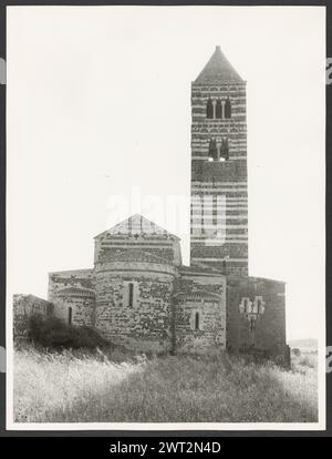 Sardinien Sassari Sassari (Environs) SS. Trinita di Saccargia (Camaldolite). Hutzel, Max 1960-1990 Außenansichten einer romanischen Kirche (12. Jahrhundert) umfassen: Eine gestreifte Fassade (dunkler Basalt und weißer Kalkstein), einen Turm mit pisanischem und lucchesischem Einfluss und verzierte/groteske Kapitelle. Antiquitäten: Zwei Säulen und Kapitelle des Portikus. Objektnotizen: Hutzel Fotokampagne Datum: 16. April 1983 der in Deutschland geborene Fotograf und Gelehrte Max Hutzel (1911–1988) fotografierte in Italien von den frühen 1960er Jahren bis zu seinem Tod. Das Ergebnis dieses Projekts, von Hutzel als Foto Arte Minore bezeichnet, ist Thorou Stockfoto