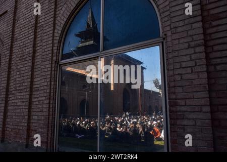 Srinagar, Indien. März 2024. Kaschmiri-Muslime, die Gemeindegebete anbieten, werden am ersten Freitag des Ramadan in Srinagar auf dem Spiegel der Großen Moschee oder Jamia Masjid reflektiert. Muslime auf der ganzen Welt markieren den Monat Ramadan, den heiligsten Monat im islamischen Kalender, in dem die Gläubigen von morgens bis abends fasten. Quelle: SOPA Images Limited/Alamy Live News Stockfoto