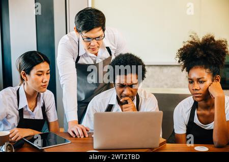 Das Café-Geschäft bringt jungen Unternehmern Freude und Spaß. Planung der Verwaltung mit einem Laptop Stockfoto