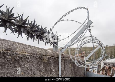 Anti-Wall-Klettern rotierende Sicherheitsspitzen und Rasierdraht als Abschreckung für Kriminalität (scharfe Widerhaken auf Sicherheitsdrehern). Schutz von Eigentum. Stockfoto