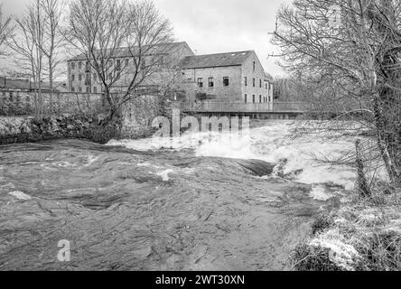 Ein donnerndes Rauschen des Wassers am Queens Rock am River Ribble, Kingsmill, Siedlung North Yorkshire. Umgebaute Mühle, jetzt Wohnungen und Brückenüberquerung. Stockfoto