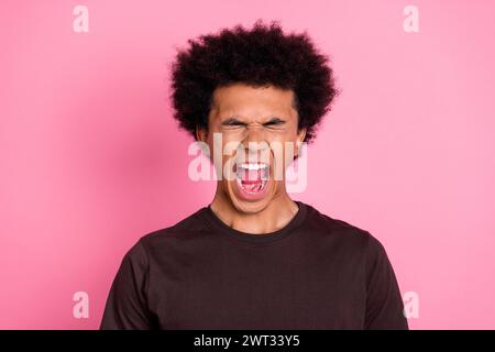 Nahaufnahme Foto von emotionalem Wahnsinn stressvoller junger lustiger wütender Kerl tragen braunes Hemd schreiend Burnout isoliert auf rosa Hintergrund Stockfoto