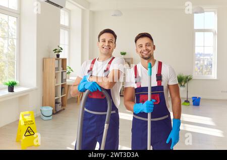 Porträt von zwei männlichen Arbeitern, die professionelle Hausreinigung erbringen. Stockfoto