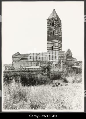 Sardinien Sassari Sassari (Environs) SS. Trinita di Saccargia (Camaldolite). Hutzel, Max 1960-1990 Außenansichten einer romanischen Kirche (12. Jahrhundert) umfassen: Eine gestreifte Fassade (dunkler Basalt und weißer Kalkstein), einen Turm mit pisanischem und lucchesischem Einfluss und verzierte/groteske Kapitelle. Antiquitäten: Zwei Säulen und Kapitelle des Portikus. Objektnotizen: Hutzel Fotokampagne Datum: 16. April 1983 der in Deutschland geborene Fotograf und Gelehrte Max Hutzel (1911–1988) fotografierte in Italien von den frühen 1960er Jahren bis zu seinem Tod. Das Ergebnis dieses Projekts, von Hutzel als Foto Arte Minore bezeichnet, ist Thorou Stockfoto