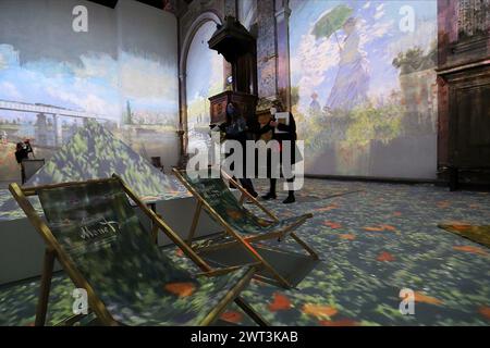 Zwei Besucher mit Masken zum Schutz vor COVID-19 sehen sich die Gemälde von Claude Monet an, die an den Wänden in der Ausstellung „Mon Stockfoto