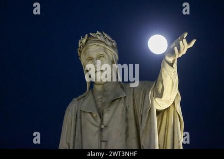 Die Statue des Dichters Dante Alighieri auf dem Platz in Neapel scheint mit dem Vollmond zu spielen. Stockfoto