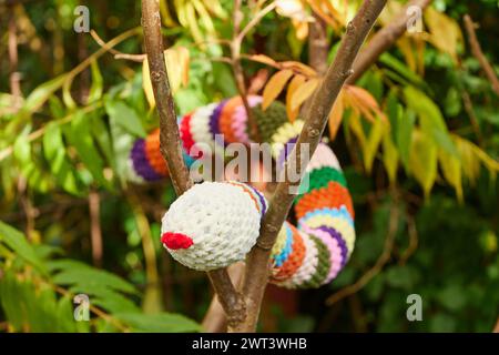 Gestrickte Spielzeugschlange auf einem Baum im Garten Stockfoto