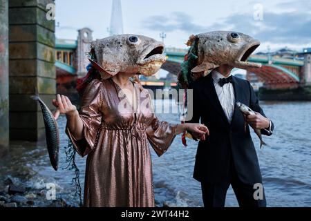 26. Oktober 2023, Fishmongers Hall, London, Großbritannien. Ozeanaufstand protestiert gegen ökologische Schäden durch Lachszucht. In der Halle veranstaltet der Marine Stewardship Council sein Annual Awards Dinner. Pressemitteilung: Am Donnerstag, den 26. Oktober, um 18:00 Uhr starteten zwei Lachsdarsteller von Ocean Rebellion vor dem Annual Awards Dinner des Marine Stewardship Council in der Fishmongers’ Hall am Ufer der verschmutzten Themse in London. Sie trugen groteske Lachsköpfe und begannen sofort ein skurriles und SKRUPELLOSES Spiel mit ROSA PONG, was die schreckliche Grausamkeit des schottischen salms hervorhob Stockfoto