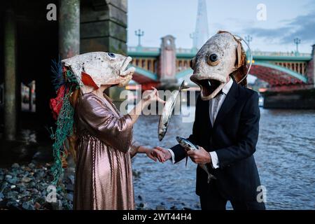 26. Oktober 2023, Fishmongers Hall, London, Großbritannien. Ozeanaufstand protestiert gegen ökologische Schäden durch Lachszucht. In der Halle veranstaltet der Marine Stewardship Council sein Annual Awards Dinner. Pressemitteilung: Am Donnerstag, den 26. Oktober, um 18:00 Uhr starteten zwei Lachsdarsteller von Ocean Rebellion vor dem Annual Awards Dinner des Marine Stewardship Council in der Fishmongers’ Hall am Ufer der verschmutzten Themse in London. Sie trugen groteske Lachsköpfe und begannen sofort ein skurriles und SKRUPELLOSES Spiel mit ROSA PONG, was die schreckliche Grausamkeit des schottischen salms hervorhob Stockfoto