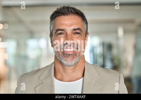 Glücklicher Geschäftsmann mittleren Alters, der im Amt steht. Kopfaufnahme im Porträt Stockfoto