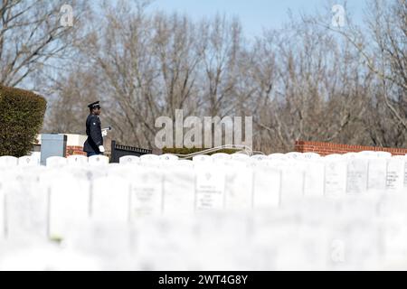 Ein ergreifender Moment entfaltet sich, während ein Soldat einen gefallenen Veteranen mit einem feierlichen Gruß ehrt und seine Internierung auf einem nationalen Militärfriedhof markiert. Stockfoto