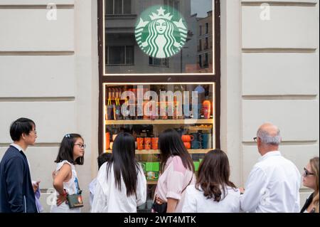 Fußgänger kommen an der amerikanischen multinationalen Kette Starbucks Coffee Store in Spanien vorbei. Stockfoto