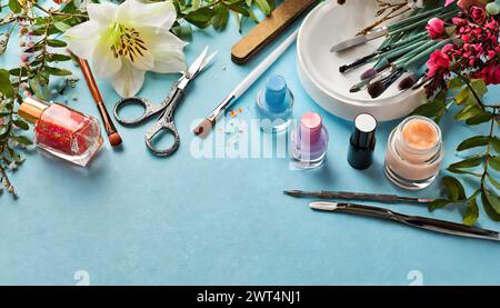 Dekoratives Set aus Kosmetik-, Make-up- und Maniküre-Produkten auf einer Blaulichttablette mit Kopierraum Stockfoto