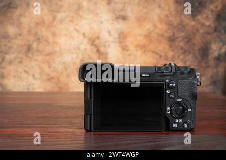 Rückseite einer Kamera auf einem Mahagoni-Tisch mit verschwommenem Hintergrund Stockfoto