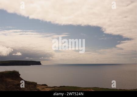 Blick von Brough of Birsay zum Kitchener Memorial am Marwick Head an der Westküste von Festland Orkney mit Wolkenbildung darüber Stockfoto