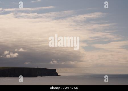 Blick von Brough of Birsay zum Kitchener Memorial am Marwick Head an der Westküste von Festland Orkney mit Wolkenbildung darüber Stockfoto