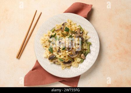 Vegetarische Pasta mit Pilzen, Petersilie, Bohnen und Käse auf orangefarbenem Tisch, Blick von oben Stockfoto