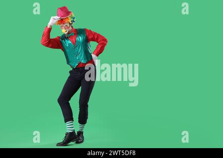 Porträt des Clowns in stilvollem Hut auf grünem Hintergrund. Aprilfeier zum Narrentag Stockfoto