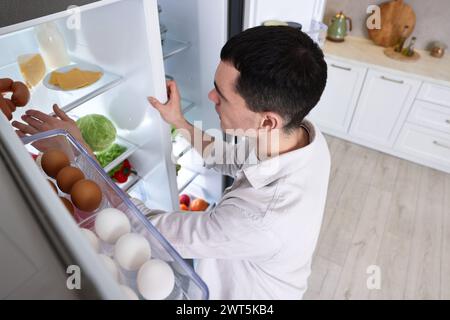 Mann in der Nähe des Kühlschranks in der Küche zu Hause, über der Aussicht Stockfoto