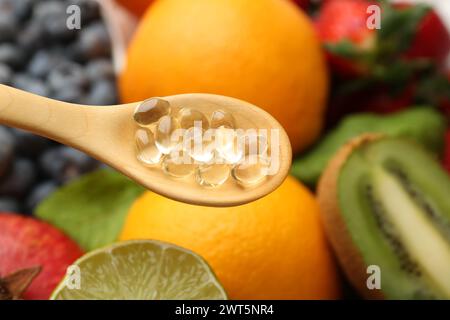 Vitaminpillen im Löffel über frischem Obst, Nahaufnahme Stockfoto