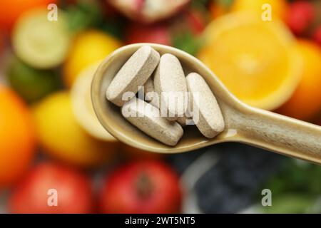 Vitaminpillen im Löffel über frischem Obst, Blick von oben Stockfoto