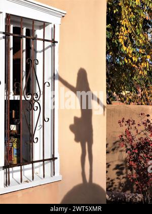 Tanzender Mädchenschatten am Galeriefenster Stockfoto