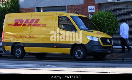 Seitenansicht eines DHL-Lieferwagens, eines Mercedes Benz Sprinters mit gelber Lackierung, der in der Straße in den Vororten von Melbourne geparkt ist Stockfoto