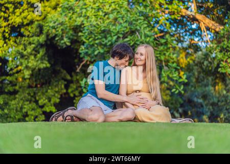 Schwangere Frau und ihr Mann verbringen schöne Zeit im Freien, genießen die Gesellschaft des anderen und genießen die Ruhe der Natur Stockfoto