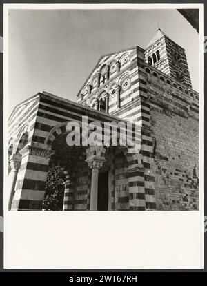 Sardinien Sassari Sassari (Environs) SS. Trinita di Saccargia (Camaldolite)3. Hutzel, Max 1960-1990 Außenansichten einer romanischen Kirche (12. Jahrhundert) umfassen: Eine gestreifte Fassade (dunkler Basalt und weißer Kalkstein), einen Turm mit pisanischem und lucchesischem Einfluss und verzierte/groteske Kapitelle. Antiquitäten: Zwei Säulen und Kapitelle des Portikus. Objektnotizen: Hutzel Fotokampagne Datum: 16. April 1983 der in Deutschland geborene Fotograf und Gelehrte Max Hutzel (1911–1988) fotografierte in Italien von den frühen 1960er Jahren bis zu seinem Tod. Das Ergebnis dieses Projekts, von Hutzel als Foto Arte Minore bezeichnet, ist Thoro Stockfoto