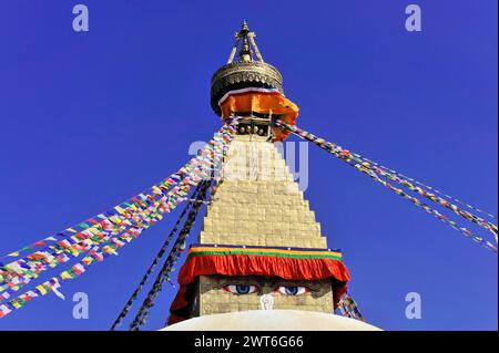 Bodnath oder Boudhanath oder Boudha Stupa, UNESCO-Weltkulturerbe, buddhistische Stupa mit flatternden Gebetsfahnen vor einem klaren blauen Himmel, Kathmandu Stockfoto