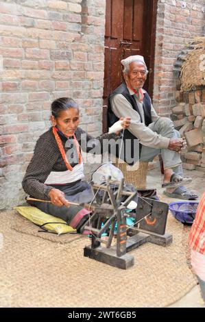 Ältere Menschen spinnen traditionell Wolle auf der Straße, Kathmandu Valley. Kathmandu, Nepal Stockfoto