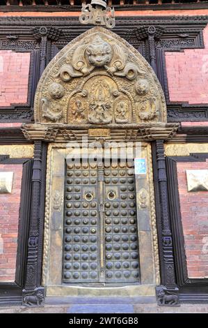 Detaillierte geschnitzte Holztür eines traditionellen Newar-Gebäudes in Nepal, Kathmandu Valley. Kathmandu, Nepal Stockfoto